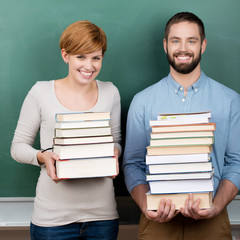 zwei studenten tragen schwere bücher