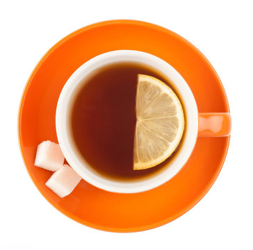 Orange teacup with sugar and lemon.