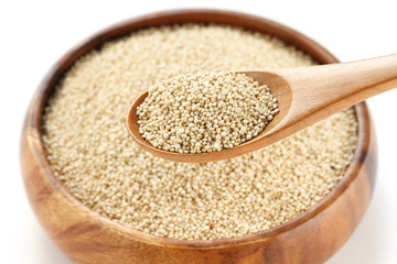 uncooked quinoa in the wooden bowl and spoon