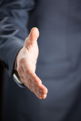 Businessman offering handshake to you - closeup shot
