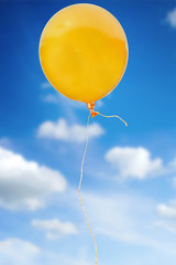 orange balloon with rope flying in the sky