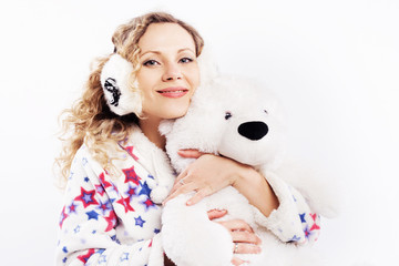 Cute woman in pajamas and headphones with teddy bear