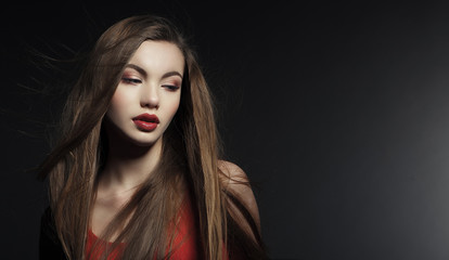 Fototapeta premium Portrait of a beautiful young woman in a red dress.