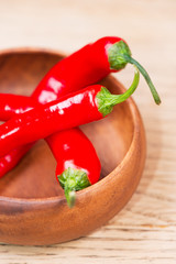 Fresh red chili pepper on wooden bowl