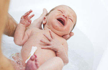 newborn is bathed in the bathroom