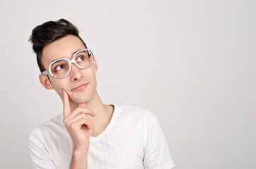 Young man with funny glasses thinking.Looking up wondering.