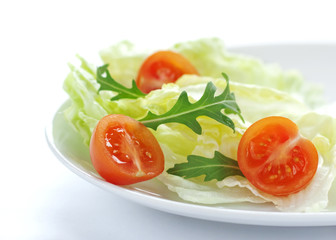 Fresh salad mix with cherry tomatoes and rucola on white plate