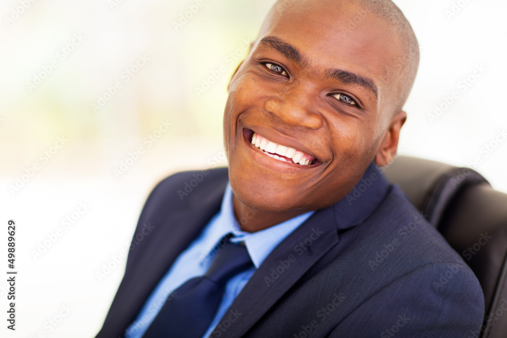 Wall mural cheerful african american office worker sitting on office chair