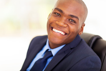 Fototapeta premium cheerful african american office worker sitting on office chair