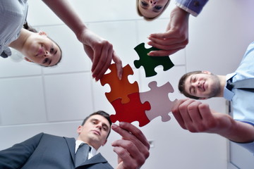 Group of business people assembling jigsaw puzzle