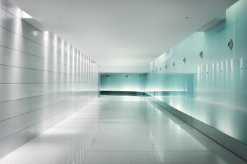Back-lighted glass walls in an underground futuristic corridor