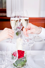 Paar sitzt lachend im Restaurant anstoßen mit Sekt
