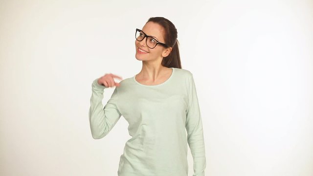 Gutaussehende junge Frau mit schwarzer Brille zeigt nach oben