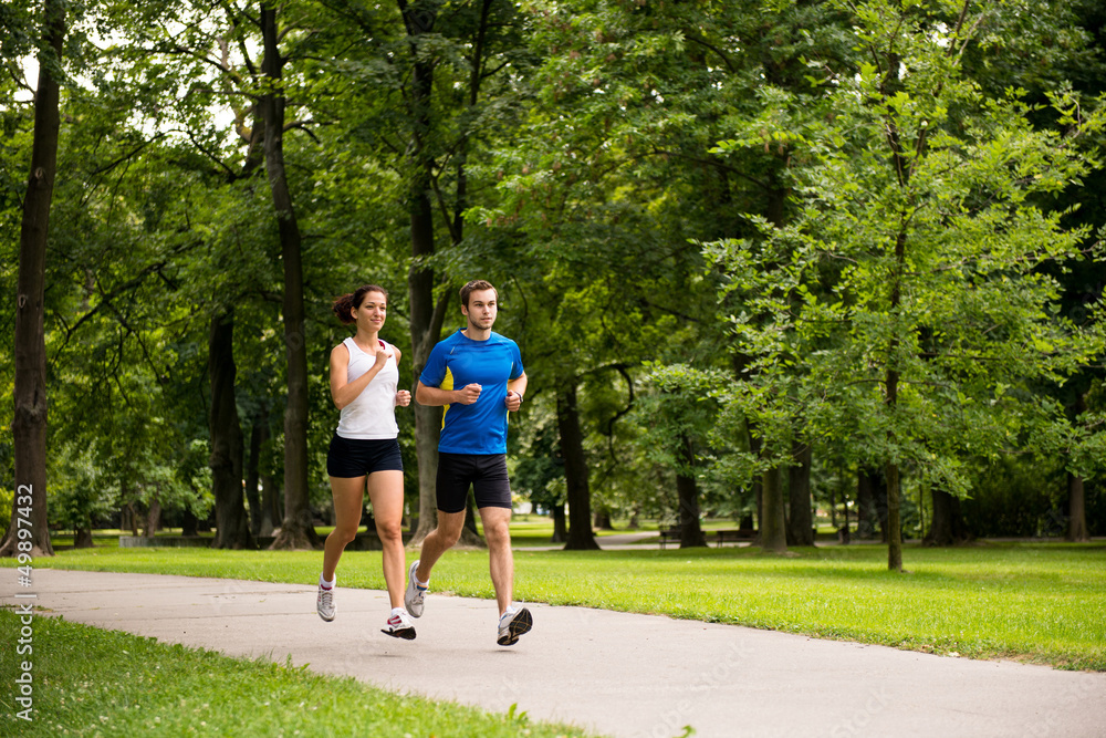 Wall mural Jogging together - young couple running