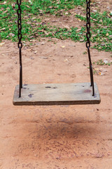 Old wooden swing on the playground in the park