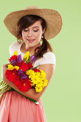 Woman wearing straw hat holding spring flower