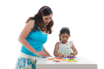 happy looking indian mother and daughter learning with education