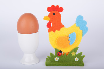 Braunes Hühnerei mit Deko Hahn