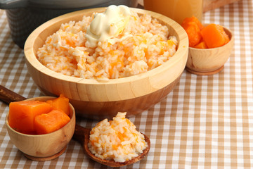 Taste rice porridge with pumpkin and glass of juice