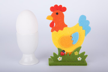 weißes Hühnerei mit Deko Hahn