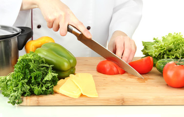 Female hands cutting vegetables, isolated on white