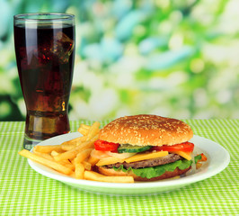 Tasty cheeseburger with fried potatoes and cold drink,