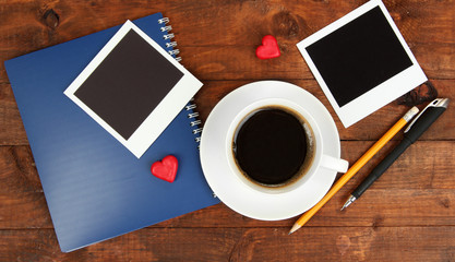 Cup of coffee on worktable covered with photo frames close up