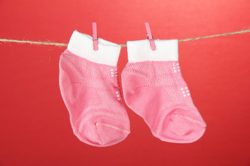 Colorful socks hanging on clothesline, on color background