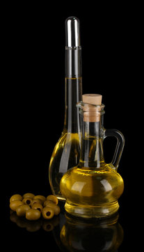 Different types of oil with olives on dark background