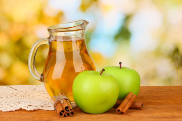 Full jug of apple juice and apple