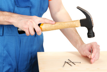 Builder hammering nails into board isolated on white