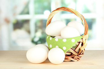 Many eggs in basket on table in room