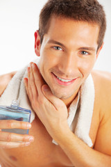 Young man applying after shave
