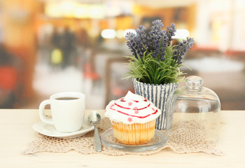 Cupcake on saucer with glass cover, on bright background