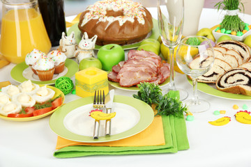 Serving Easter table with tasty dishes on room background
