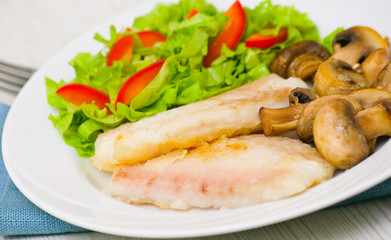 Fish fillet with mushrooms and salad