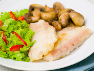 Fish fillet with mushrooms and salad