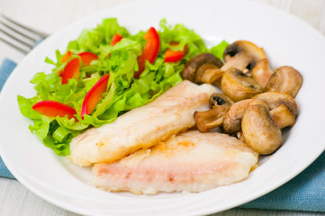 Fish fillet with mushrooms and salad