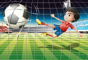 Foto op Aluminium Een jongen die de bal schopt op het voetbalveld © GraphicsRF