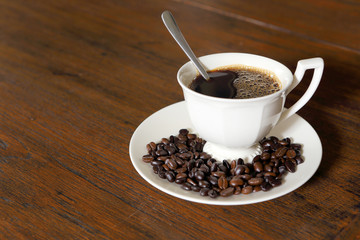 Coffee cup with Coffee Beans on grunge wood