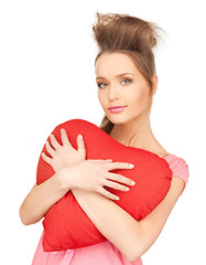 happy and smiling woman with heart-shaped pillow