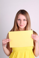 Fototapeta na wymiar Romantic girl wearing yelow clothing and showing blank card