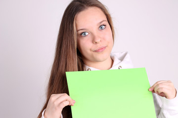Fototapeta na wymiar teenage girl wearing sport clothes and showing white blank card 