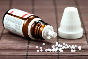 Glasflasche mit homöopathischen Globuli 
