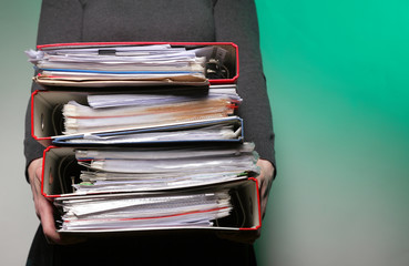 Female office worker carrying a stack of files