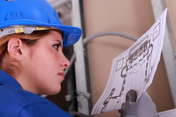 Female electrician reading diagram