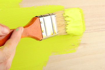 Brush painting wooden furniture, close up