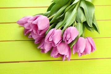 Beautiful bouquet of purple tulips on green wooden background