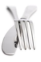 close up of a fork and knife over white