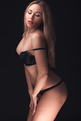 Fototapeta na wymiar Beautiful and sexy woman wearing sensual lingerie on black backg